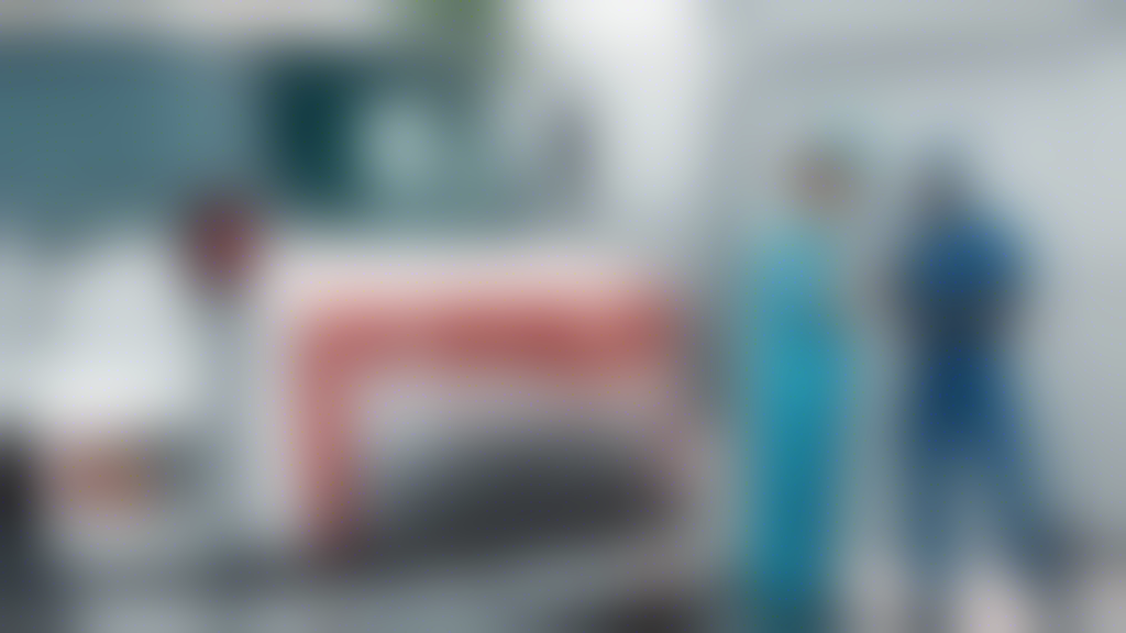 Create an image showing a healthcare professional conducting a DOT physical examination on a commercial truck driver. Include various medical instruments like a stethoscope, blood pressure monitor, and eye chart in the background to depict the common tests and procedures involved. The setting should be a standard medical examination room. The driver should appear calm and attentive, while the healthcare professional explains the process, highlighting preparation and the importance of passing the exam.